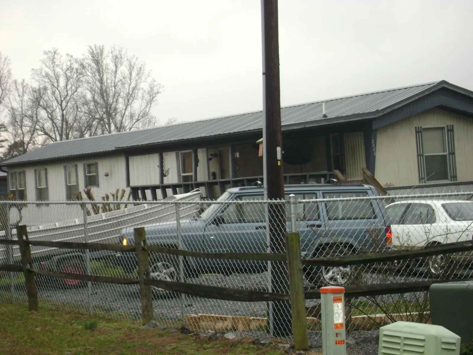 Dark metal roof on a long single story building behind a chain link fence in Tiptonville