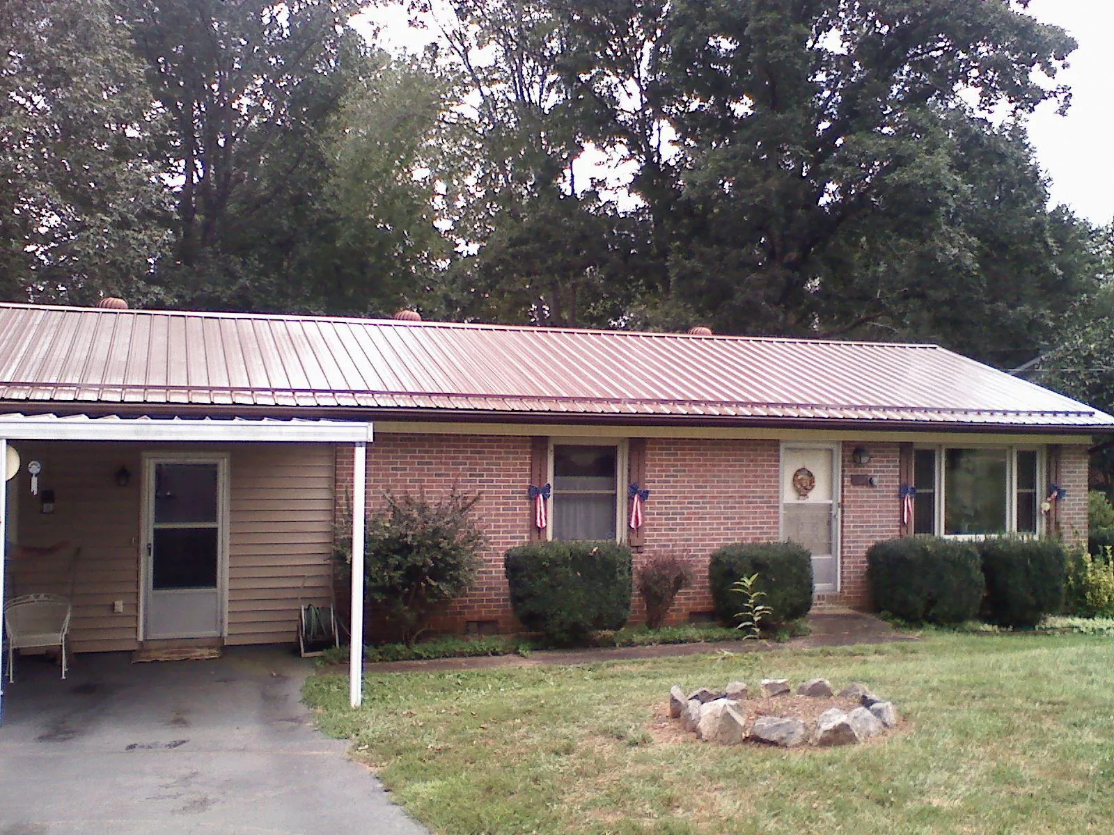 Bronze metal roof and carport on a brick ranch home — Roof Repair work by our crew in Tiptonville